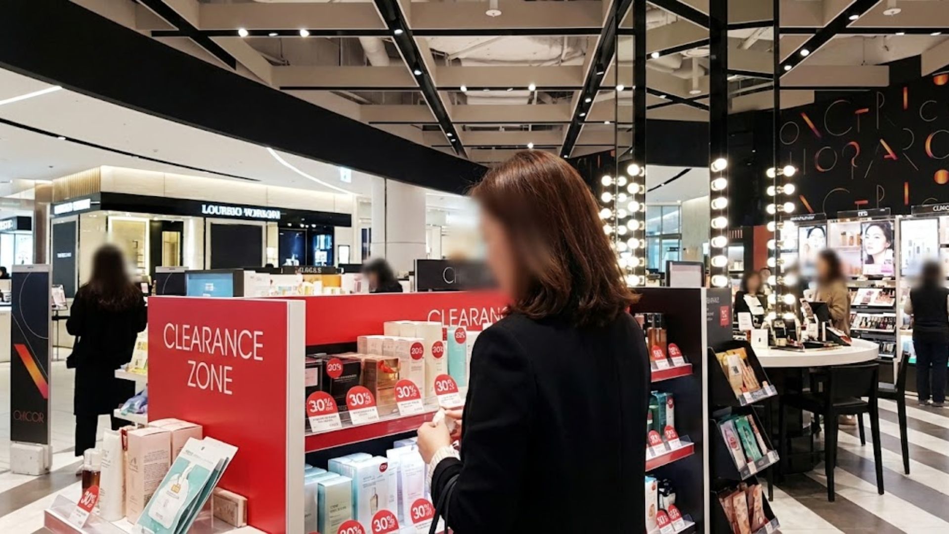 시코르 매장 내 화장품 싸게 사는 곳인 클리어런스 존에서 할인 스티커가 붙은 제품을 고르는 모습